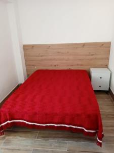 um quarto com um cobertor vermelho numa cama em Alcôa House em Alcobaça