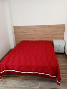 - une chambre avec une couverture rouge sur un lit dans l'établissement Alcôa House, à Alcobaça