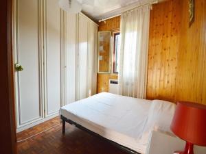 Cama en habitación con paredes de madera y ventana en Piana, Bologna by Short Holidays, en Bolonia