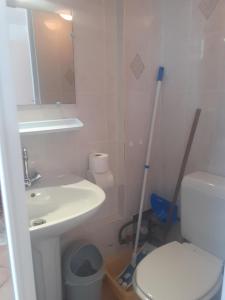 ein Badezimmer mit einem WC, einem Waschbecken und einem Spiegel in der Unterkunft Studio Neptune in Arromanches-les-Bains