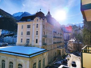 a building in a city with the sun behind it at Bad Gastein Historic Center in Bad Gastein