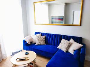 een blauwe bank in een woonkamer met een spiegel bij Bad Gastein Historic Center in Bad Gastein