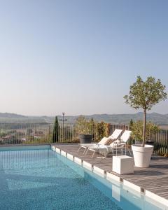 una piscina con 2 tumbonas y un árbol en una terraza en Villa Alma Vista en Dobrovo