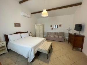 SternatiaにあるAgriturismo Masseria Chicco Rizzoのベッドルーム(ベッド1台、ソファ、テレビ付)