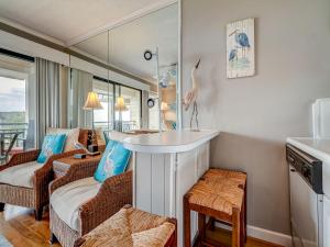 een woonkamer met een tafel en stoelen en een kamer bij Seaside Villa 332, 1 Bedroom, Pool, Oceanside, 3rd Floor, Wi-Fi, Sleeps 4 in Hilton Head Island