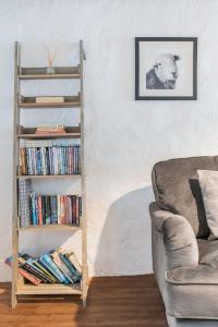 a book shelf filled with books next to a couch at Potter's Wheel in High Nibthwaite
