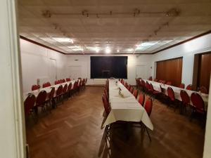 een conferentieruimte met tafels en stoelen en een scherm bij Gasthaus Frörup in Oeversee