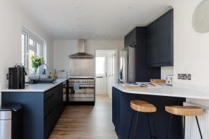 a kitchen with black and white cabinets and wooden floors at Sunseekers - Colwell Bay in Totland