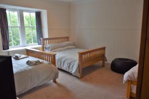 En eller flere senge i et værelse på Coachmans Cottage