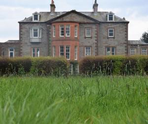 an old house in a field of tall grass at Coachmans Cottage in Carsethorn