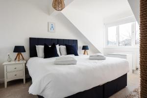 a bedroom with a large white bed with blue pillows at Sunseekers - Colwell Bay in Totland