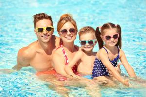 a family in the water at a swimming pool at Beautiful Lodge With Full Sea Views At Broadland Sands In Suffolk Ref 20235bs in Hopton on Sea