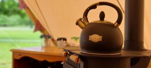 a black tea kettle sitting on top of a table at Park Farm Holidays Glamping in Lyndhurst