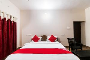 a bedroom with a large bed with red pillows at OYO Flagship 64921 Purple Villa in Bhubaneshwar