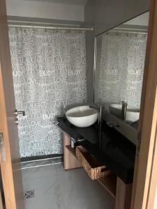 łazienka z 2 umywalkami i dużym lustrem w obiekcie Leloir Premium w mieście Villa Marini