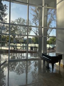 a piano in a room with a large window at Leloir Premium in Villa Marini