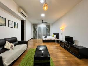 ein Wohnzimmer mit einem Sofa und einem TV in der Unterkunft Regalia Suites KL Infinity Pool _ by MygeHomes in Kuala Lumpur