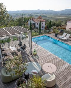a backyard with a swimming pool and a wooden deck at Villa Alma Vista in Dobrovo
