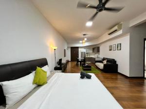 ein Schlafzimmer mit einem großen Bett und ein Wohnzimmer in der Unterkunft Regalia Suites KL Infinity Pool _ by MygeHomes in Kuala Lumpur