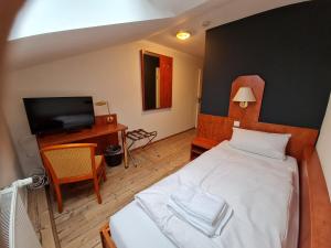 een slaapkamer met een wit bed en een televisie bij Gasthaus Frörup in Oeversee