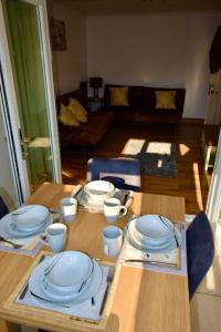 a wooden table with plates and cups on top of it at Great Bentleys Great Retreat in Great Bentley