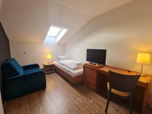 een slaapkamer met een bed en een bureau met een televisie bij Gasthaus Frörup in Oeversee