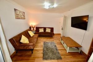 a living room with two couches and a television at Great Bentleys Great Retreat in Great Bentley