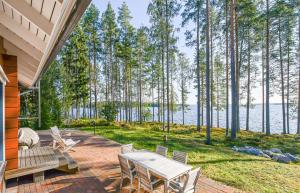 a patio with a table and chairs and a view of the water at Aava Koli in Kolinkylä
