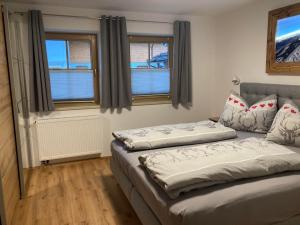 two beds in a room with two windows at Appartement Stefanie in Hollersbach im Pinzgau