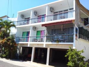 un edificio de apartamentos blanco con balcones y palmeras en Appart-hotel Veras Samana No 13, en Santa Bárbara de Samaná
