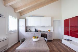 uma cozinha com armários brancos e uma mesa de madeira em Ca MIA Ciclamino & Genziana Apartments em Vicenza