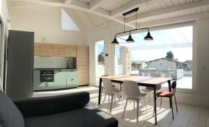 Una cocina y un comedor con mesa y sillas. en Attico 24, Residence Gardalido, en Padenghe sul Garda