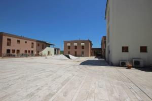 un parking vide avec des bâtiments en arrière-plan dans l'établissement Quercegrossa 10, à Quercegrossa