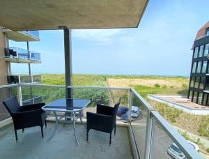 a patio with a table and chairs on a balcony at Terminated in Cadzand