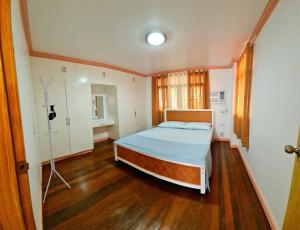 a bedroom with a bed and a wooden floor at 150 Lucap Road in Alaminos