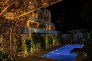 een gebouw met een zwembad in de nacht bij Jungle hideaway 2BR/plunge pool in Tulum