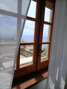 una ventana abierta con vistas al océano en Casa Teranga en Furore