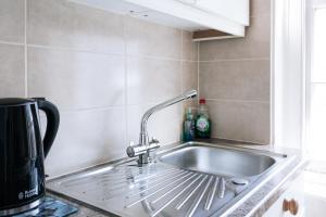a kitchen sink with a faucet on a counter at Evelyn Court in London