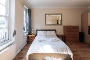 een slaapkamer met een bed met twee handdoeken erop bij Evelyn Court in Londen