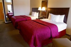 a hotel room with two beds with red blankets at Cedars Inn in Wenatchee