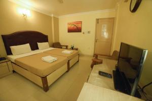 a bedroom with a bed and a flat screen tv at HOTEL UDUPI INTERNATIONAL in Nāgercoil