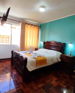 a bedroom with a large bed in a room with blue walls at Hotel Express in La Paz