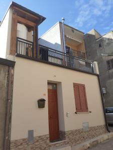 a white house with a balcony and a door at LA TERRAZZA in Ioppolo Giancaxio