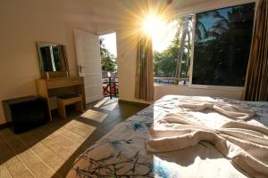 a bedroom with a bed and a large window at Surf Yoga Camp in Thulusdhoo