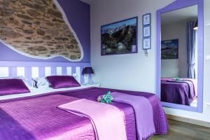 Dormitorio púrpura con cama y espejo en Casa Novecento, en Feltre
