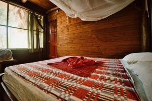 a bedroom with a bed with a quilt on it at Hotel Casa Perico in Rio Dulce