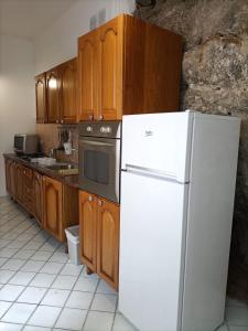 a kitchen with a white refrigerator and wooden cabinets at Casa Teranga in Furore