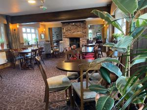 a restaurant with tables and chairs and a fireplace at The Egerton Arms Astbury in Congleton