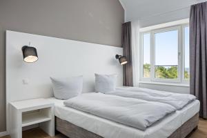 a white bedroom with a large bed and a window at Strandresidenzen Binz-Prora Strandresidenzen Binz-Prora V5 1 in Binz