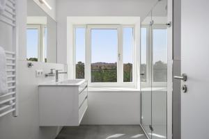a white bathroom with a shower and a window at Strandresidenzen Binz-Prora Strandresidenzen Binz-Prora V5 1 in Binz +9 photos